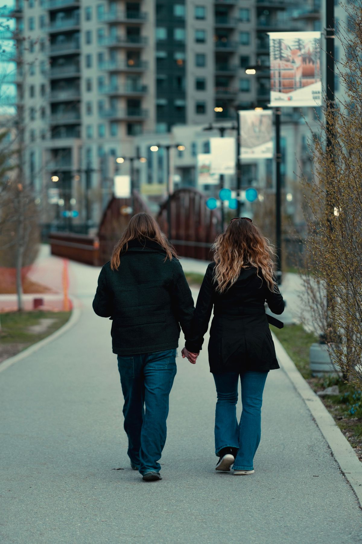 A couple walking hand in hand through a park in Waterloo, Ontario